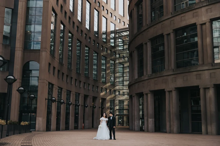 Wedding couple posing between brick buildings