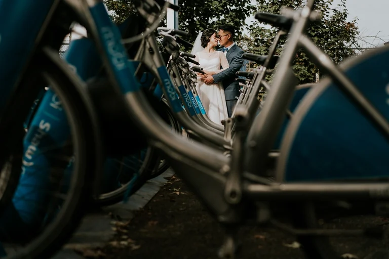 Wedding couple reflected in the window of a bicycle