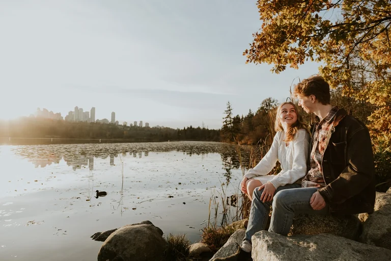 Wedding couple sitting beside a quiet lake