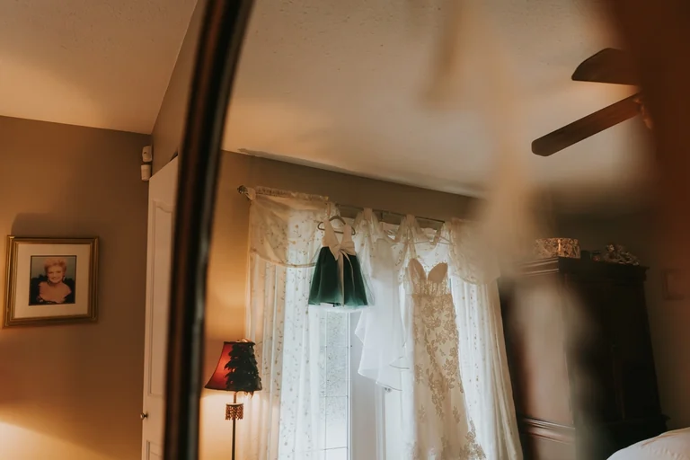 Wedding dress hanging near a window
