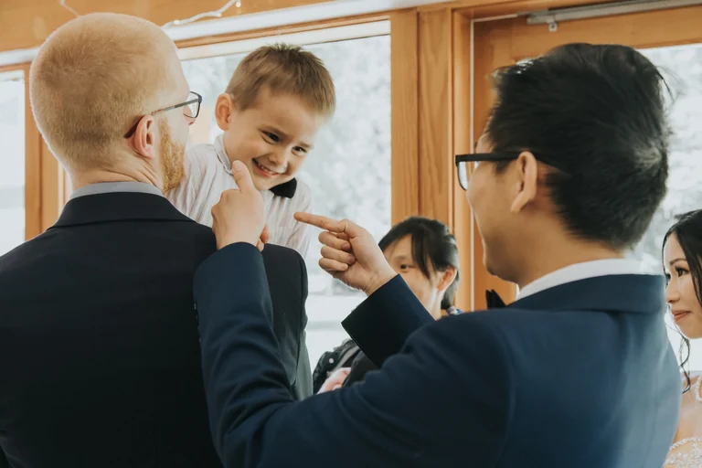Wedding guests smiling with a young child