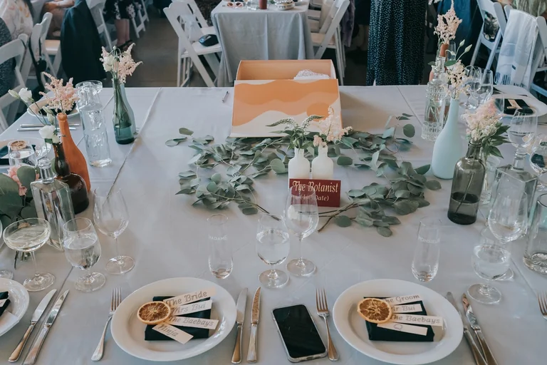 Wedding reception table with greenery and place cards