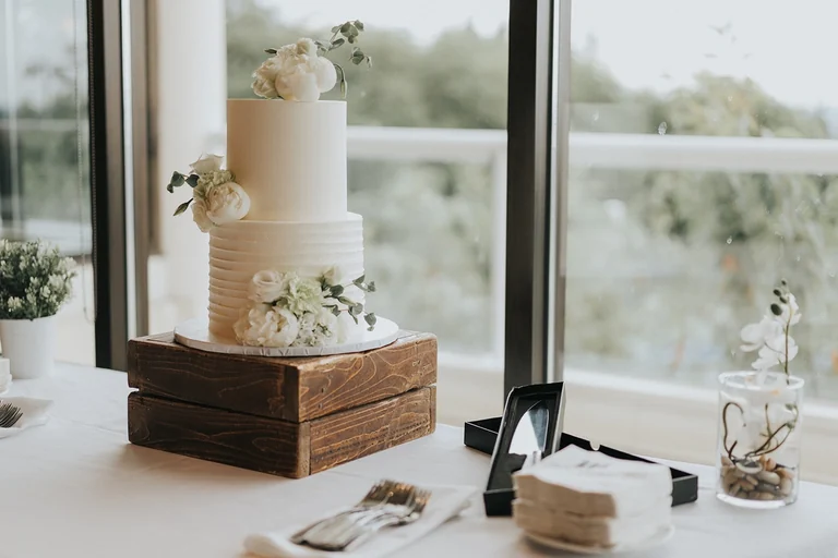 White wedding cake displayed beside a window
